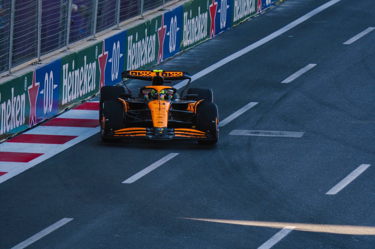 about-02 A Formula 1 racing car speeding along the Baku City Circuit during a race event.