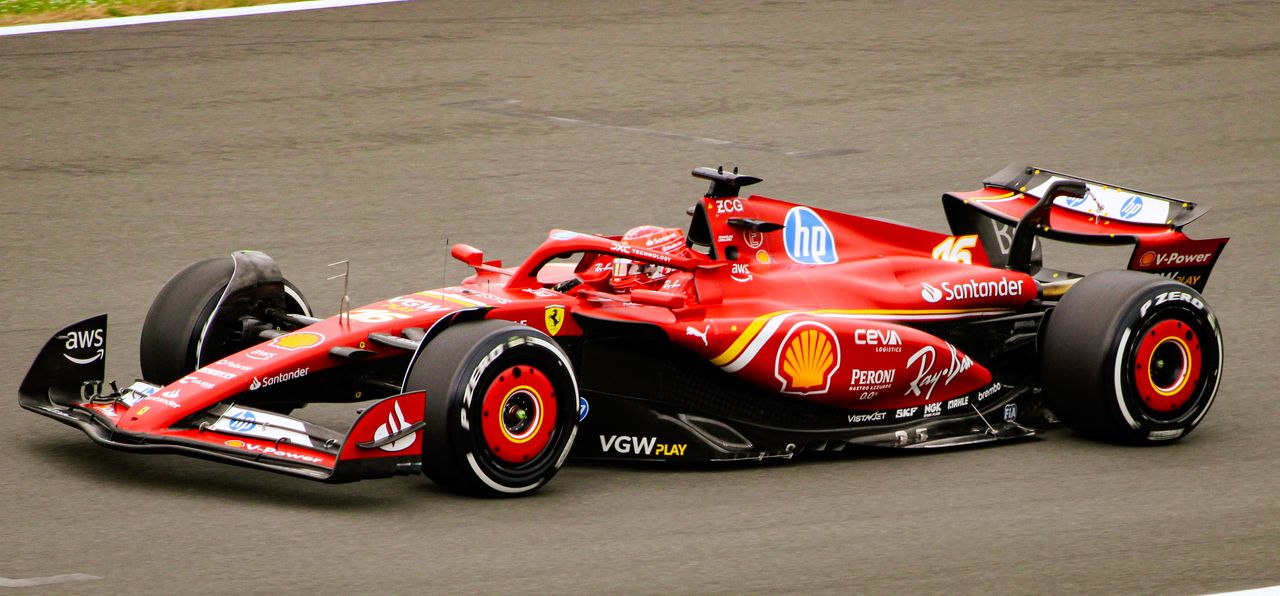 A dynamic shot of a red Formula 1 car speeding on the race track, showcasing racing energy.