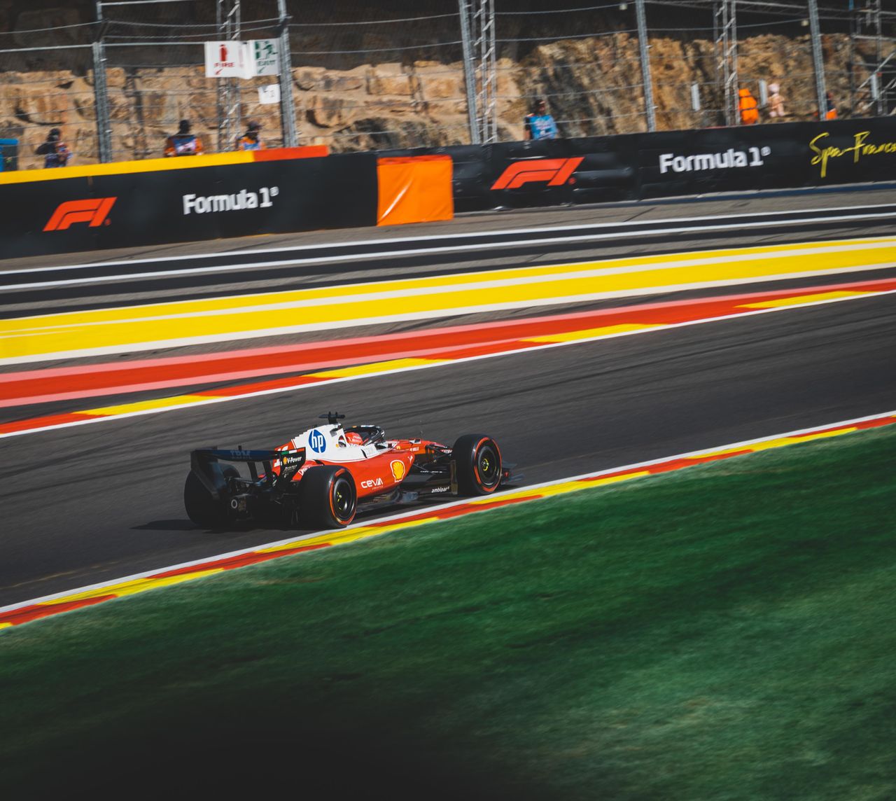 Dynamic shot of a Formula 1 car racing on the Circuit de Spa-Francorchamps track in Belgium.